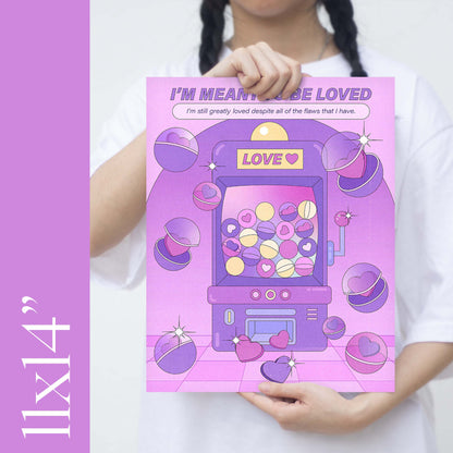 A girl holding an 11x14" size purple claw machine self-care art print with the text "i'm meant to be loved" 