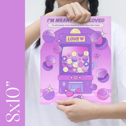 A girl holding an 8x10" size purple claw machine self-care art print with the text "i'm meant to be loved" 
