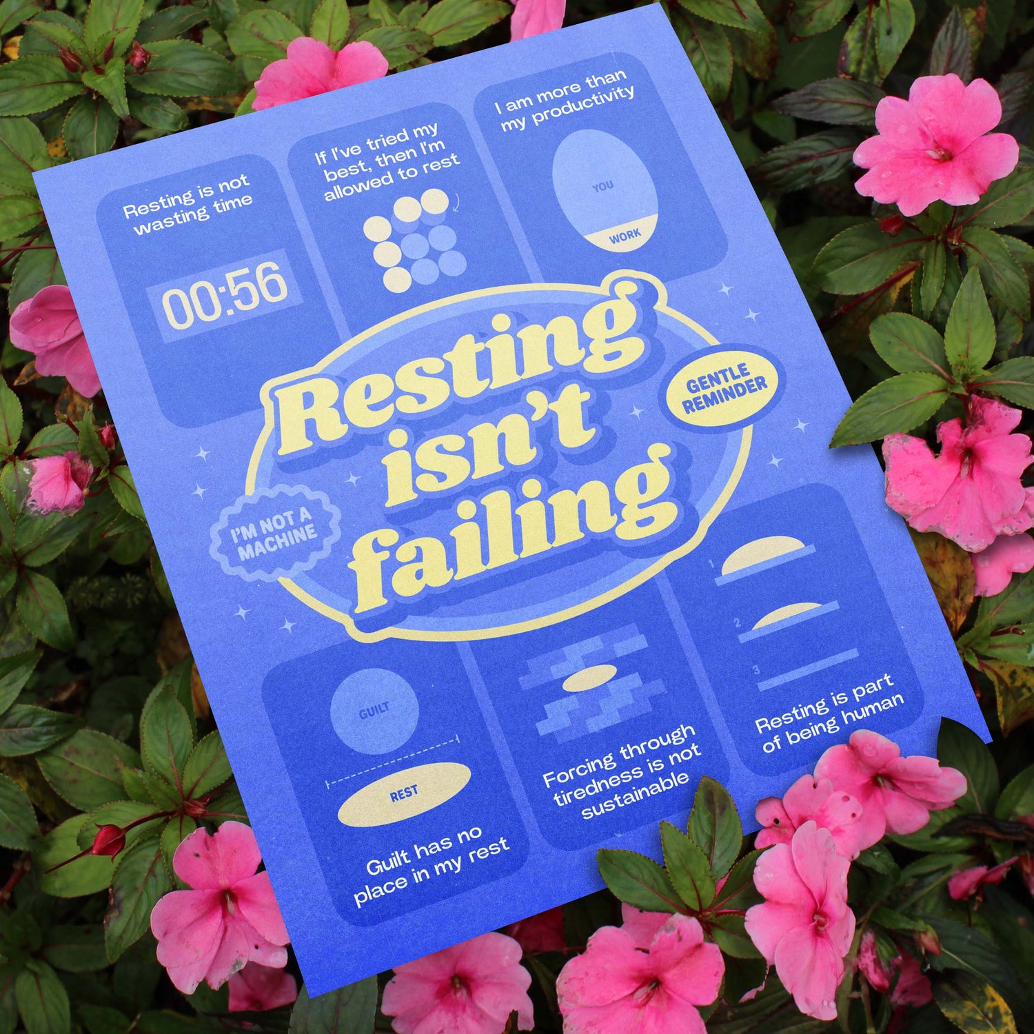 A blue self-care art print with the text "resting isn't failing" against pink floral background